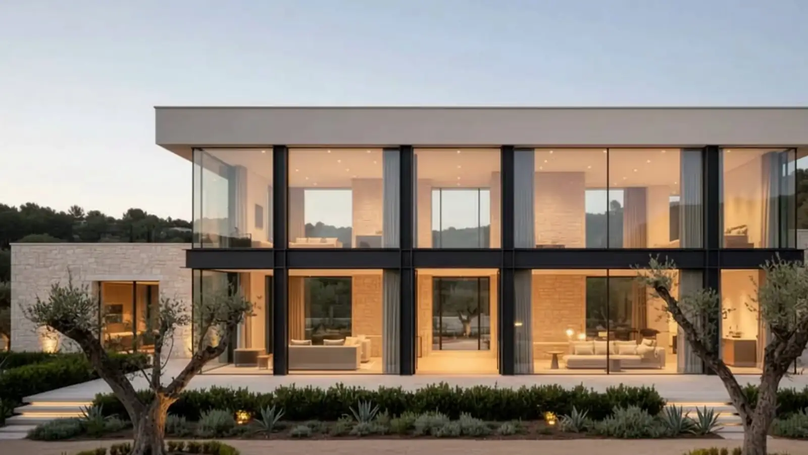 Villa contemporanea con vetrate a tutta altezza e telai neri sottili, al crepuscolo